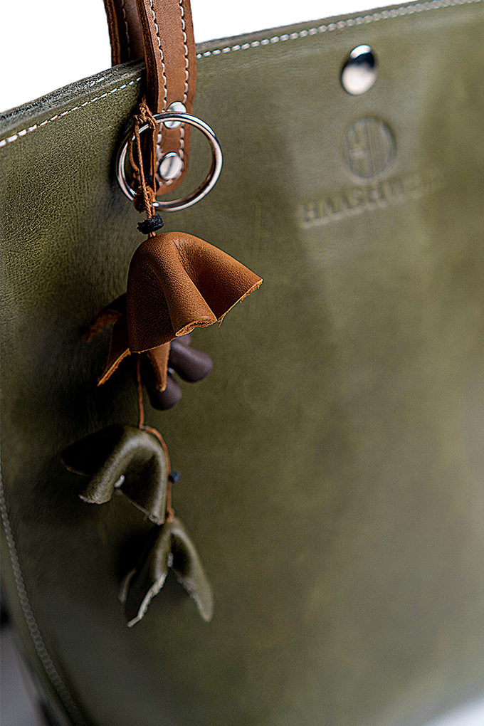 Bag charm showing next to green olive bag